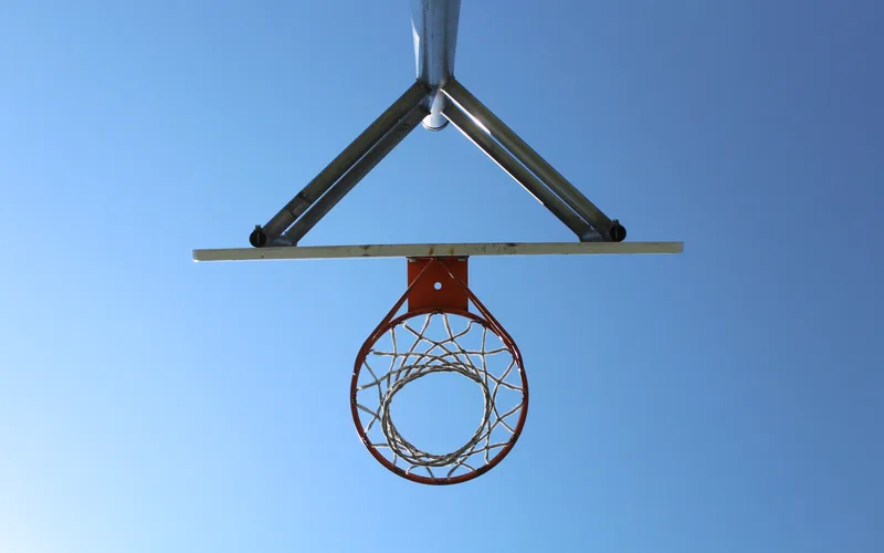 Basketball hoop viewed from below against the sky
