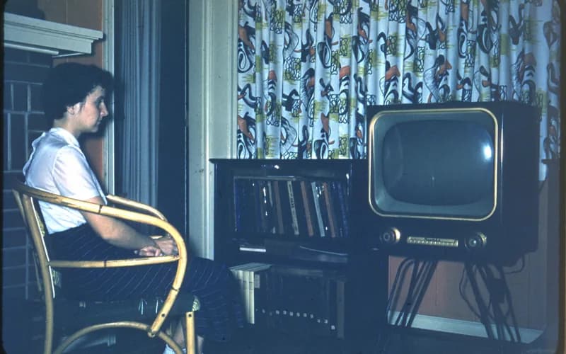 Person sitting beside a television in a living room